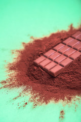 Cocoa powder pile and a milk chocolate bar