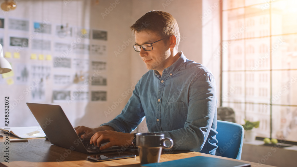 Aufkleber Professional Creative Man Sitting at His Desk in Home Office Studio Working on a Laptop. Man working with Data and Analyzing Statistics.