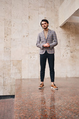 Young handsome man in checkered jacket confidently looking in camera outdoor