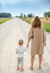 Mother and daughter on the road in countryside. Summer.