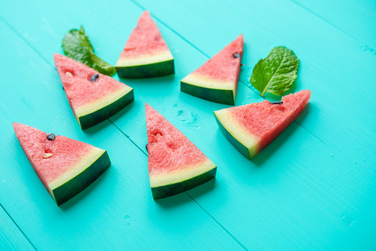 Watermelon slice with papermint on a blue rustic wood background