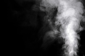 Aromatherapy. Essential oil aroma diffuser humidifier diffusing water articles in the air. Electric ultrasonic device emitting atomized water droplets against black background with copy space.