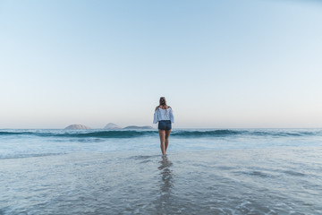 Fototapeta na wymiar Femme marchant dans l'eau sur la plage