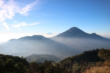 Beautiful mountains with fog and forest in the foreground