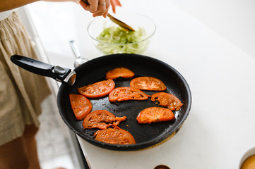 fried tomatoes in a frying pan. cherry 