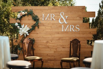 Mr & Mrs sign with chairs for newlyweds at wedding reception.