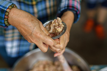 A picture of villagers cooking sausages for preserving food in the countryside.