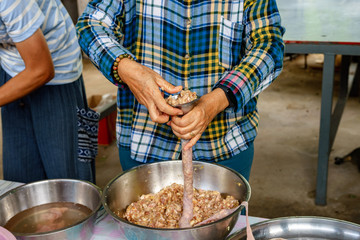 A picture of villagers cooking sausages for preserving food in the countryside.