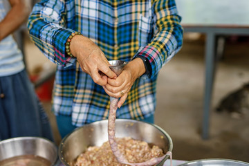 A picture of villagers cooking sausages for preserving food in the countryside.