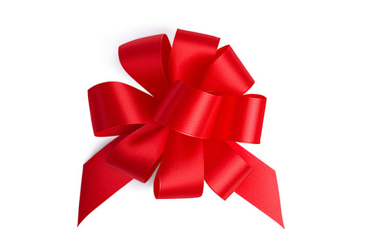 Flat lay big beautiful red ornate festive gift unusual bow with many petal loops made by hand from a red satin shiny ribbon isolated on white background
