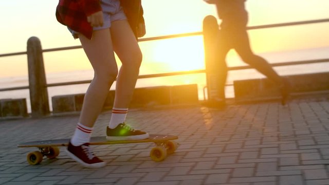 Longboard riding cruising on promenade relaxing leisure summer holiday lifestyle