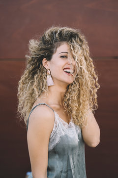 Portrait of laughing young woman with dyed blond ringlets