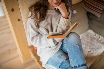 Young woman at home reading a book