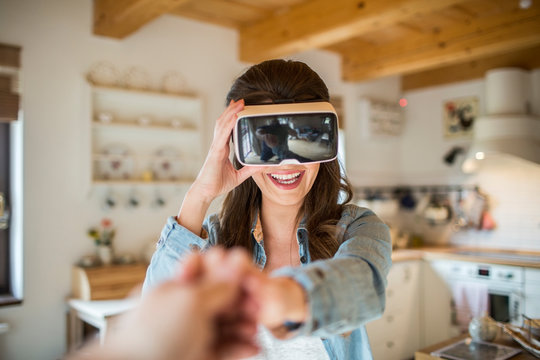 Young woman at home using Virtual Reality goggles