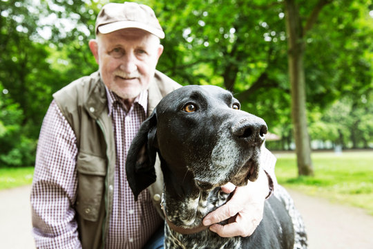 Portrait of senior man with his German Shorthaired Pointer in city park