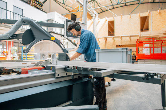 Carpenter working with saw in workshop