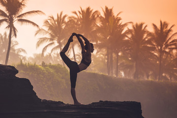 Indonesia, Bali, woman practising yoga at the coast at twilight