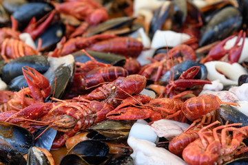 Mixed seafood cooked in a large traditional black fry pan at a street food festival, ready to eat seafood, side view, calamari, crabs, mussels with sauce