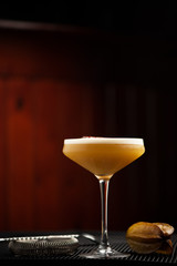 cocktail with passion fruit in tall glass on brown background bar