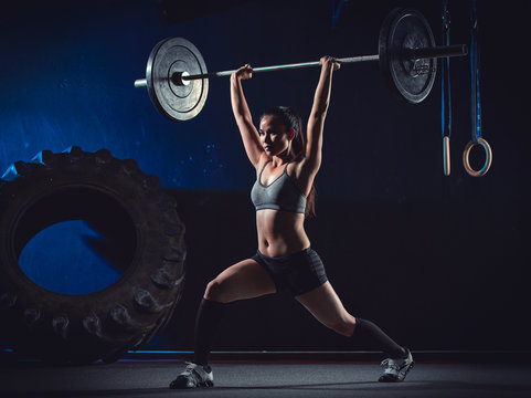 CrossFit athlete at weight training looking with barbell