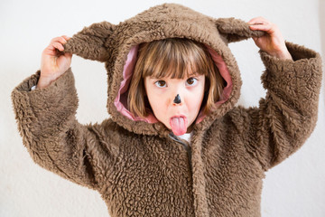 Portrait of little girl masquerade as a bear making a face