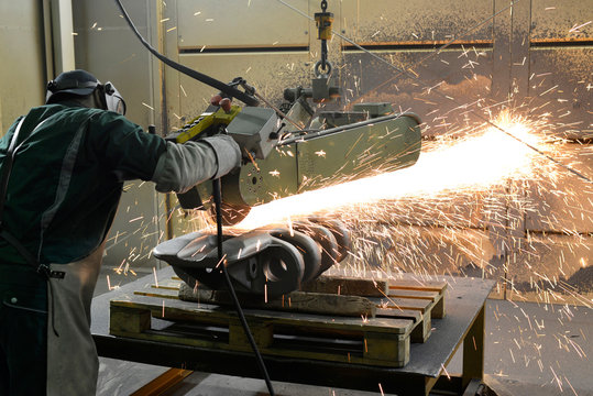 Working with belt sander in a foundry