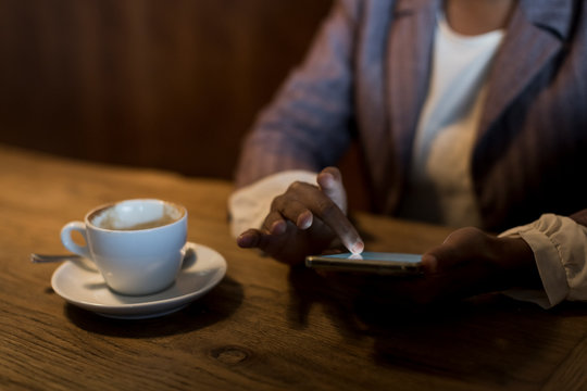 Young woman sitting in a cafe using phablet, close-up