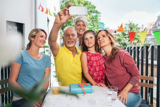 Three generations family taking a selfie on balcony