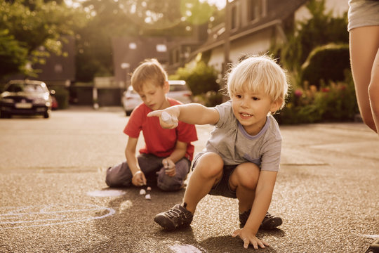 Children using sidewalk chalk in their neighborhood