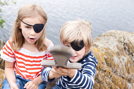 Boy and girl dressed up as pirates at a rock