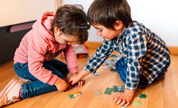 Boy and girl doing a jigsaw on the floor together