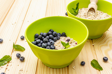 Oatmeal porridge with fresh blueberry, mint leaves and yogurt