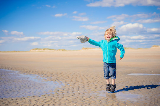 Denmark, Romo, Boy jumping at North Sea, smiling