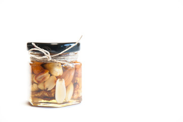 Glass jars with honey and nuts on the table. On white background.