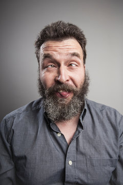 Portrait of a mature man with full beard pulling faces