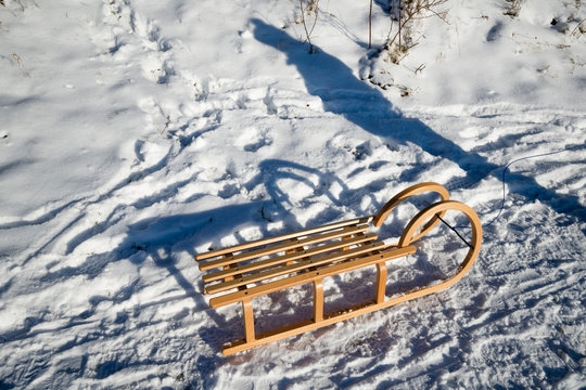 Germany, North Rhine-Westphalia, Eifel, shadow of person next to sledge in winter landscape