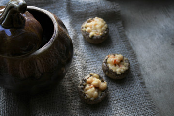 Fototapeta na wymiar Pot with baked mushrooms on a piece of cloth