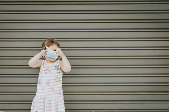 girl playing with photo camera
