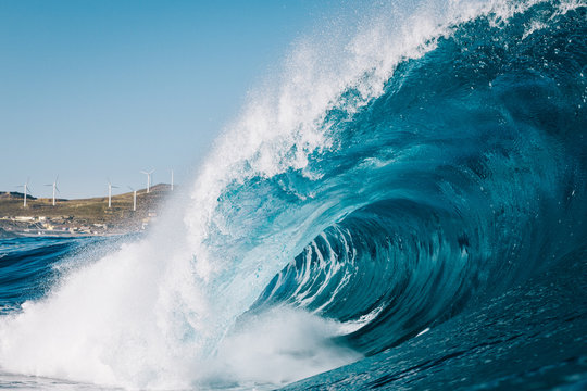 Heavy wave breaking with mountains in the background