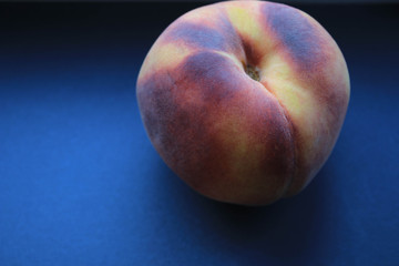 Photo of ripe peaches on a piece of fabric