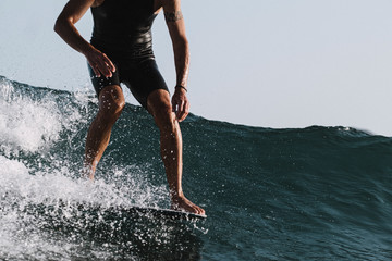 Action of lower part of man surfer on longboard nose