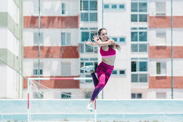Colorful image of full body of female athlete jumping on court
