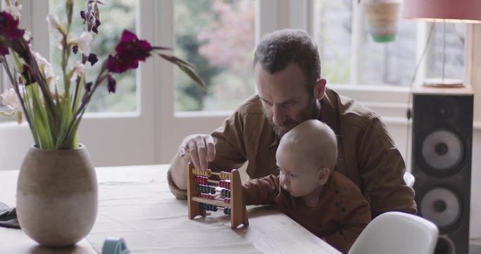 Single Father teaching his baby counting with abacus