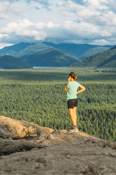 Hiker looking at green hills and lake from the edge in Washington