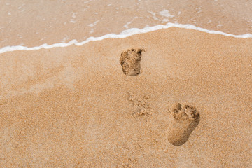 Fototapeta na wymiar Footsteps on beach for holiday travel concept. Tropical sand beach. Happy relaxing time