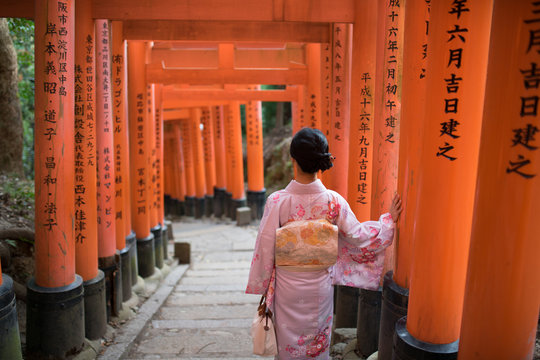 Young Asian Lady in Kimono walking along the inari in Fushimi Inari-taisha, Kyoto, Japan