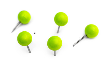 Green small office pins on white. Top view.