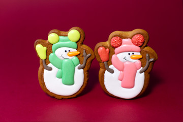 gingerbread cookie of cute snowman on red background. Traditional Christmas food. Christmas and New Year holiday concept.