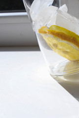 Glass with lemon, ice and water