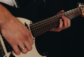 Fototapeta na wymiar Close up shot of a man with his fingers on the guitar frets